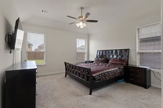 a bedroom with a bed window and a table in it