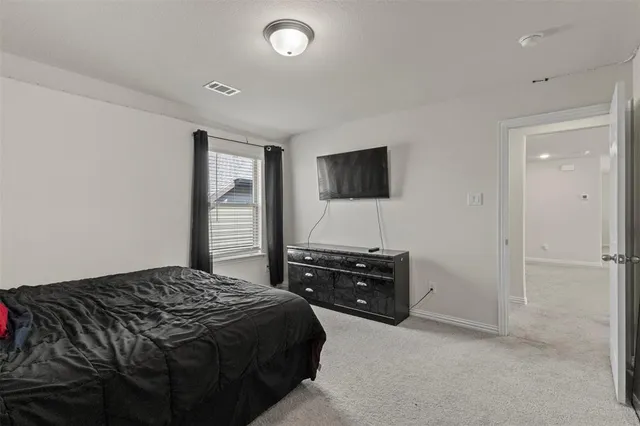 a bedroom with a bed and a flat tv screen in it