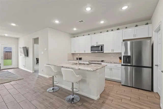 a kitchen with stainless steel appliances a refrigerator stove microwave and cabinets