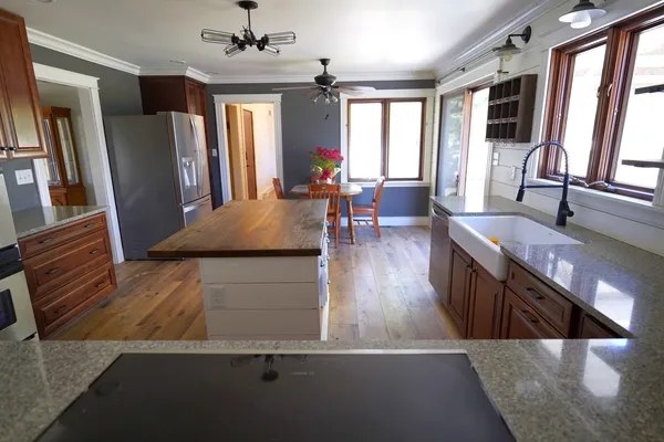 a living room with stainless steel appliances granite countertop furniture wooden floor and a large window