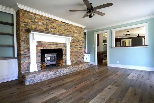 a view of empty room with wooden floor and fireplace