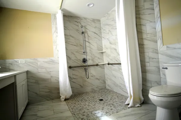 an empty room with wooden floor closet and windows