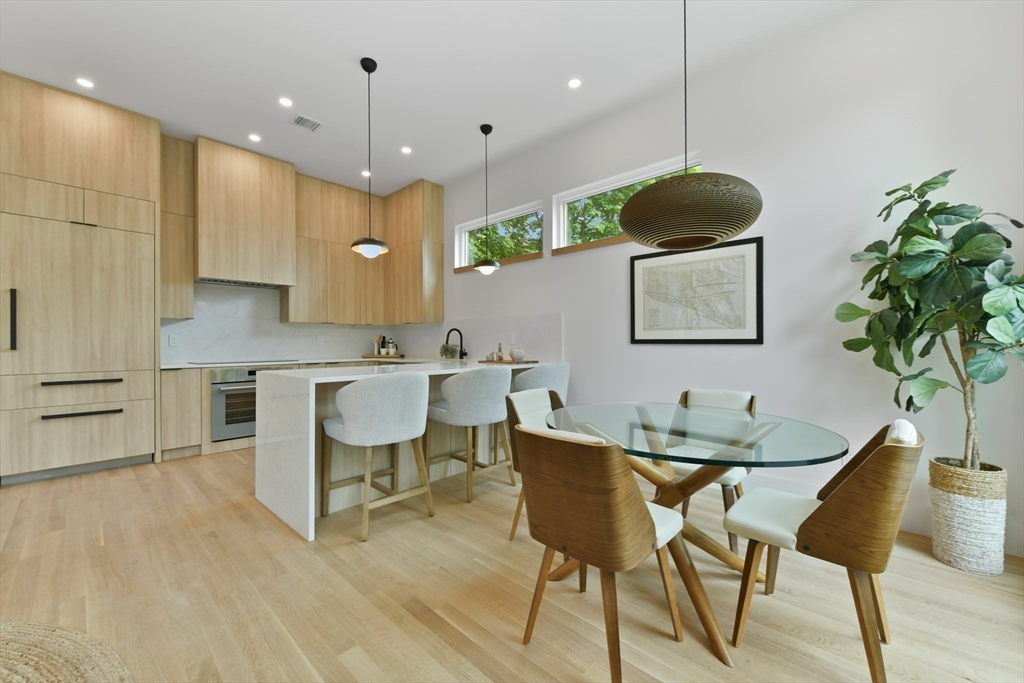 23 Eastman Road Somerville, MA 02143 - Photo 4 of 18 a kitchen with a table chairs sink and cabinets