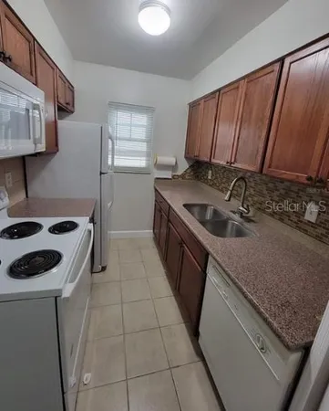 a kitchen with a sink stove top oven and cabinets