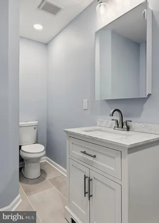 a bathroom with a toilet a sink and mirror