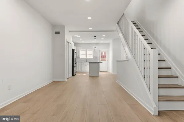 a view of a kitchen with wooden floor and electronic appliances