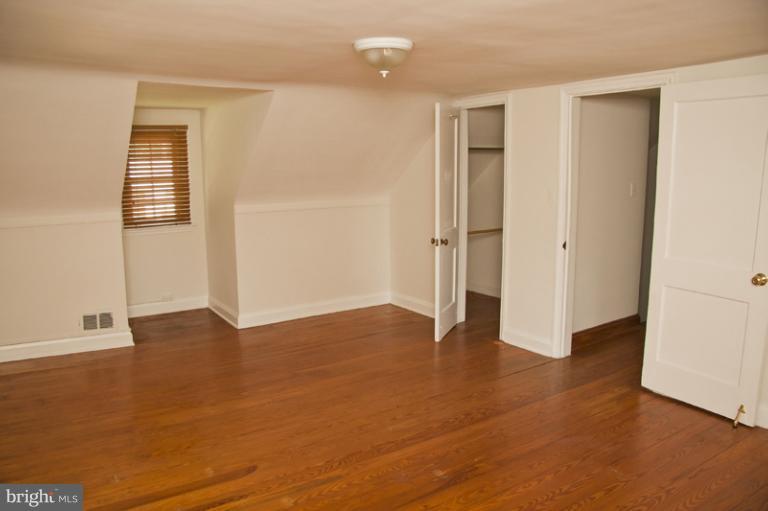 703 Sudbrook Road Pikesville, MD 21208 - Photo 11 of 15 an empty room with wooden floor and windows