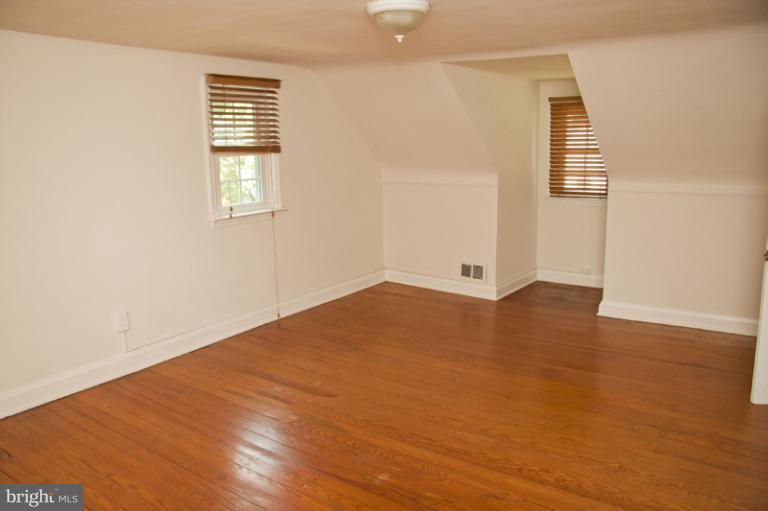 703 Sudbrook Road Pikesville, MD 21208 - Photo 14 of 15 an empty room with wooden floor and windows