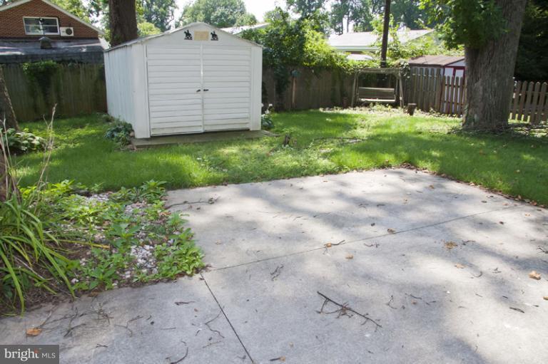 703 Sudbrook Road Pikesville, MD 21208 - Photo 3 of 15 a backyard of a house with plants and large tree