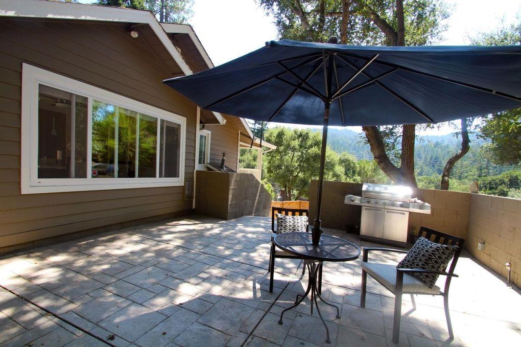 21390 Aldercroft Heights Road Los Gatos, CA 95033 - Photo 21 of 23 a backyard of a house with table and chairs under an umbrella