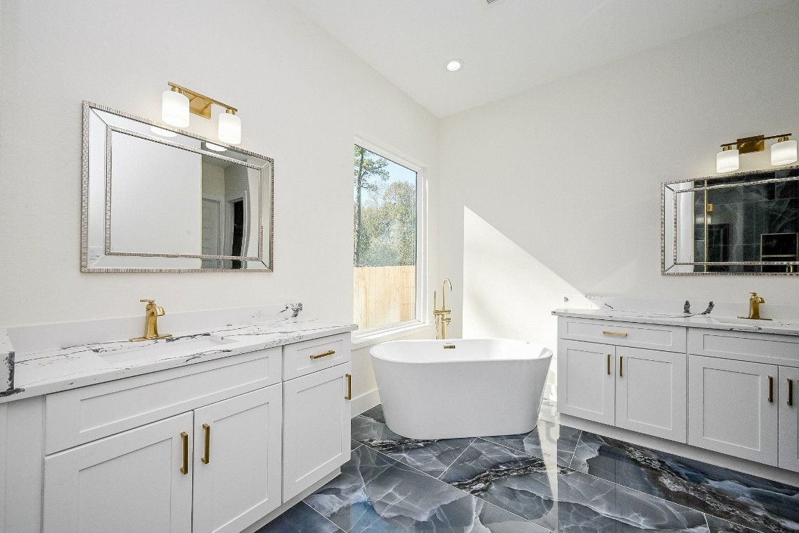 21614 Lee Road Humble, TX 77338 - Photo 18 of 36 a bathroom with a double vanity sink mirror and bathtub