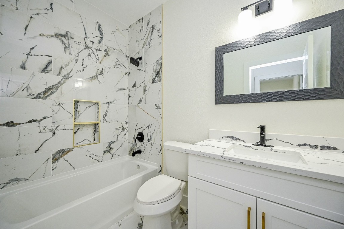 21614 Lee Road Humble, TX 77338 - Photo 23 of 36 a bathroom with a granite countertop sink a toilet and a bathtub