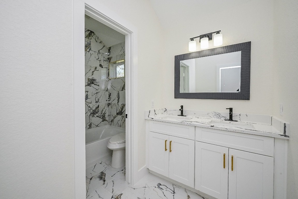 21614 Lee Road Humble, TX 77338 - Photo 24 of 36 a bathroom with a toilet sink and mirror