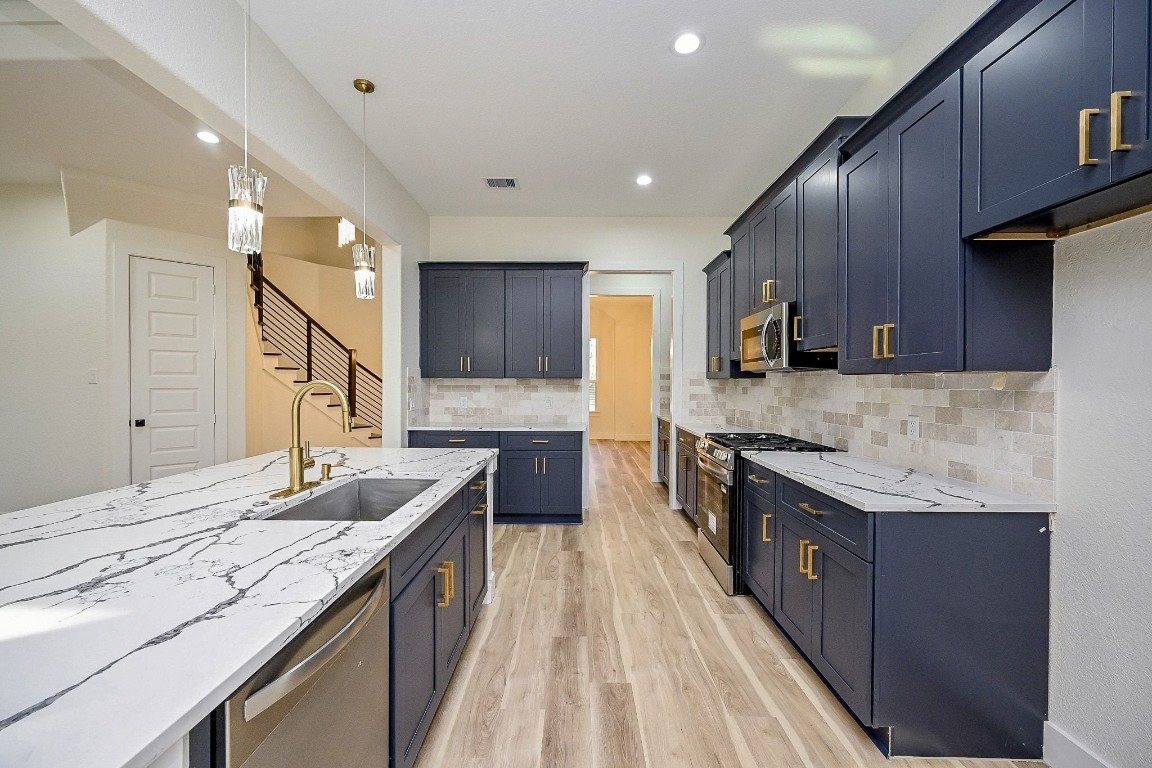 21614 Lee Road Humble, TX 77338 - Photo 5 of 36 a kitchen with granite countertop stainless steel appliances and wooden cabinets