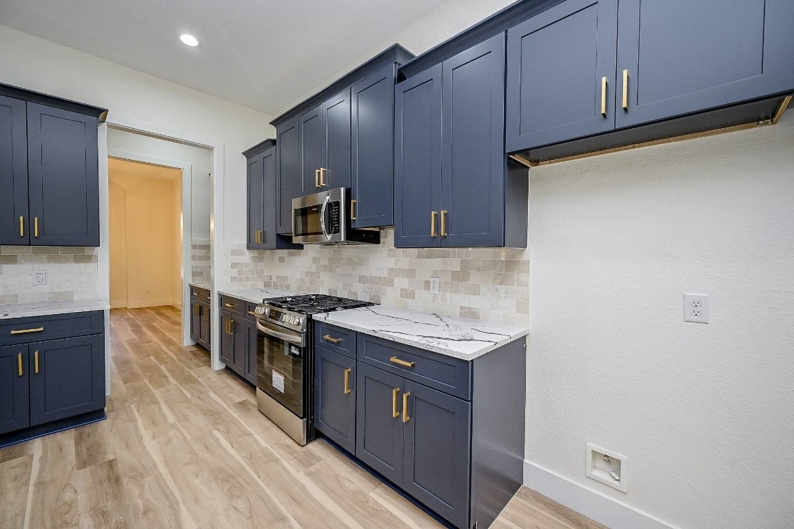 21614 Lee Road Humble, TX 77338 - Photo 6 of 36 a kitchen with stainless steel appliances granite countertop wooden cabinets a stove top oven a sink and dishwasher