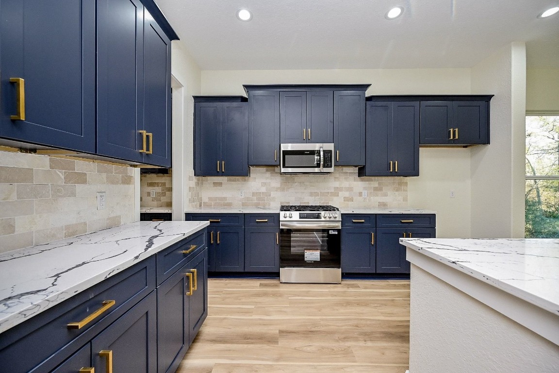 21614 Lee Road Humble, TX 77338 - Photo 7 of 36 a kitchen with stainless steel appliances granite countertop wooden cabinets a stove top oven a sink and dishwasher
