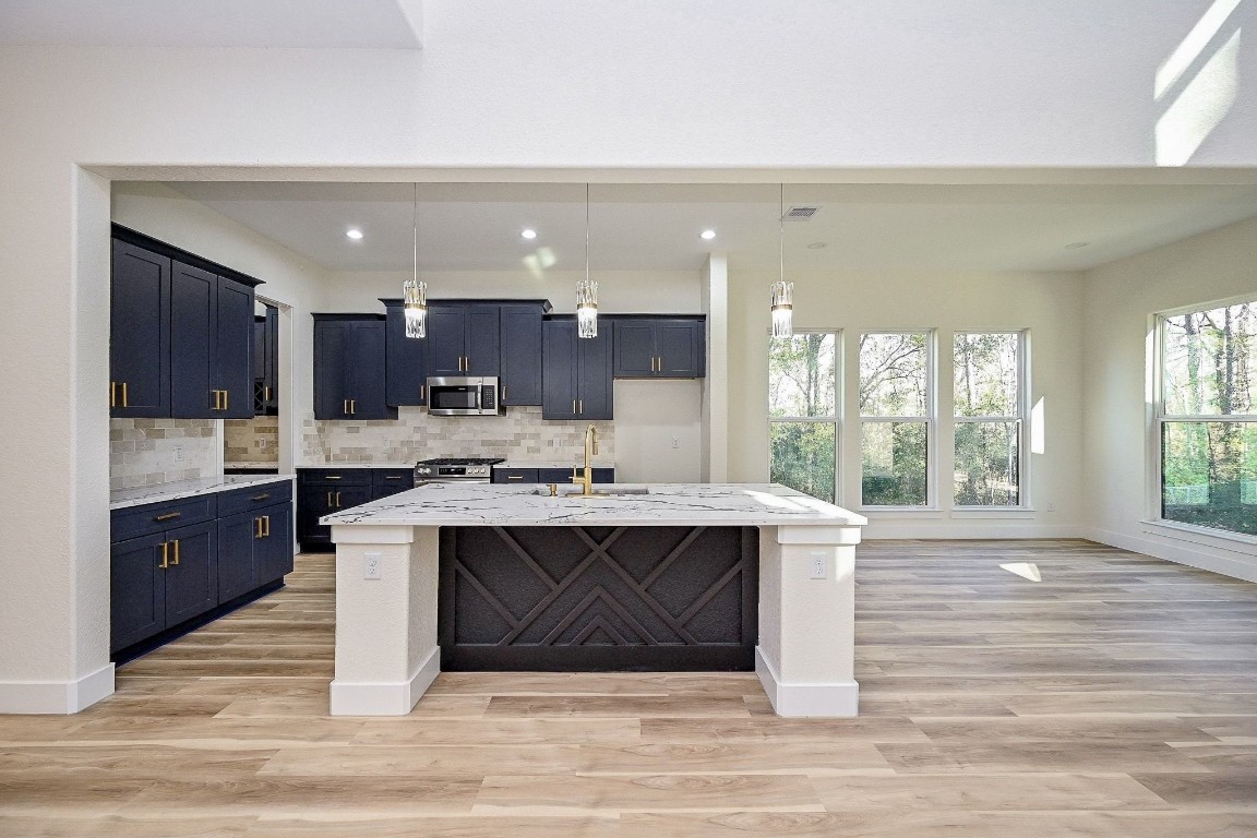 21614 Lee Road Humble, TX 77338 - Photo 9 of 36 a kitchen with kitchen island a sink cabinets and wooden floor