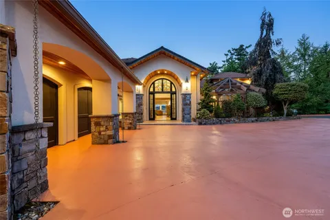 a view of a house with a large tree and a yard