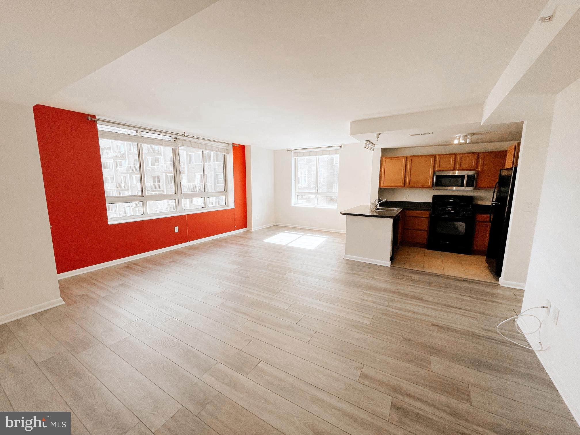 350 G Street Southwest, Unit N501 Washington, DC 20024 - Photo 26 of 49 a view of a kitchen and an empty room with wooden floor