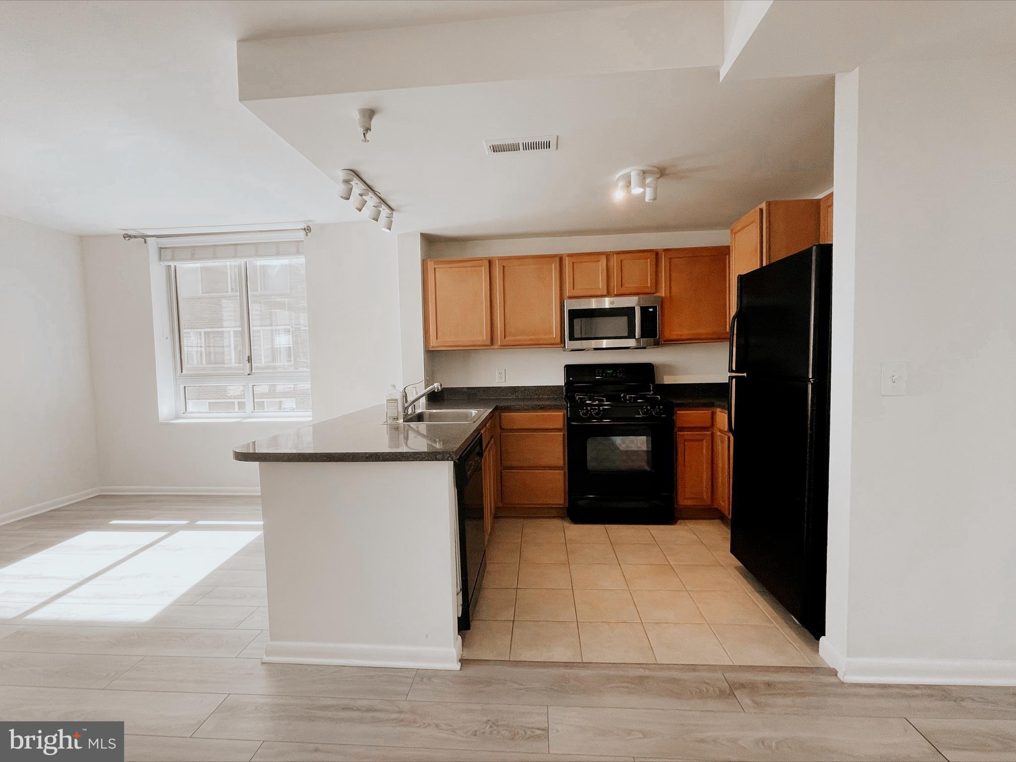 350 G Street Southwest, Unit N501 Washington, DC 20024 - Photo 27 of 49 a kitchen with granite countertop a refrigerator and a stove top oven