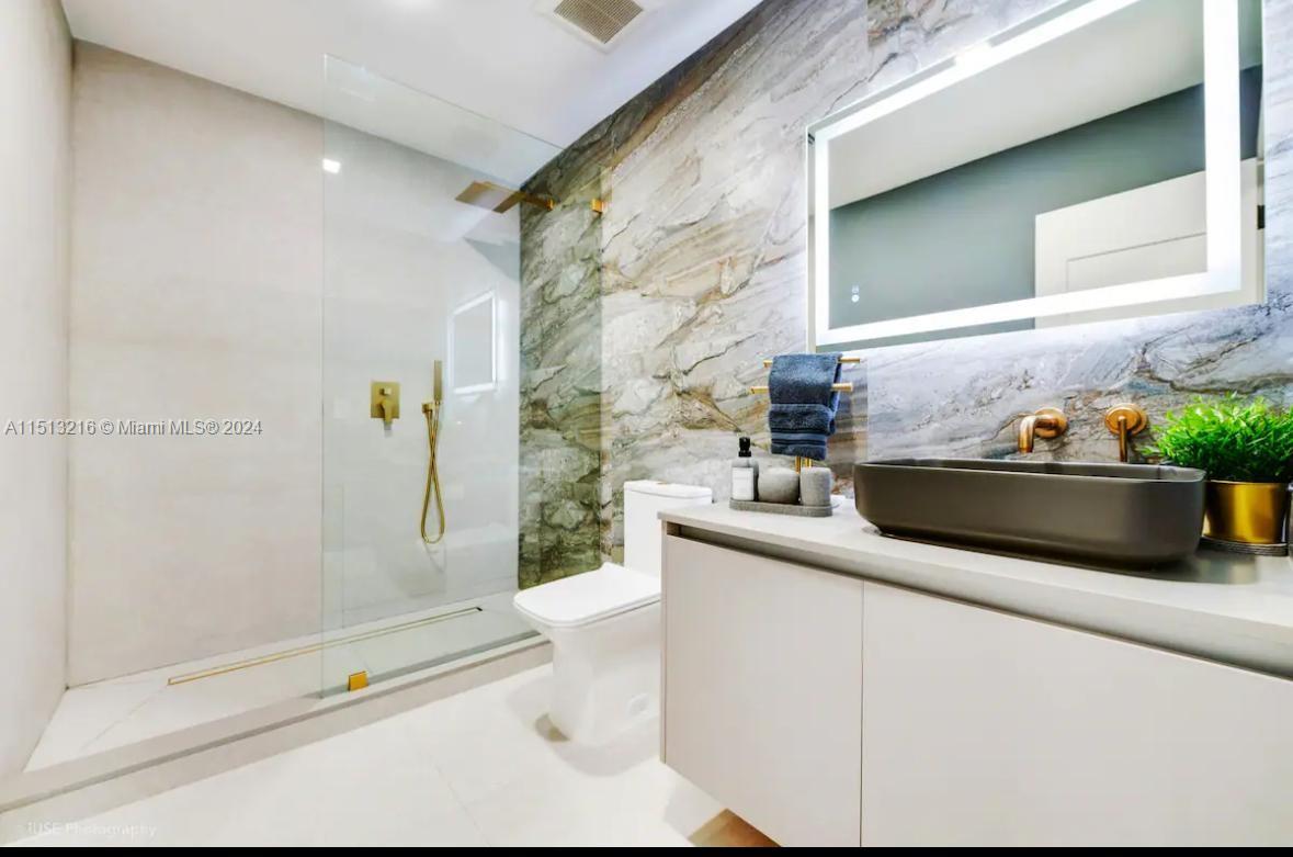 4021 Southwest 124th Court Miami, FL 33175 - Photo 6 of 8 a bathroom with a granite countertop sink a toilet and shower