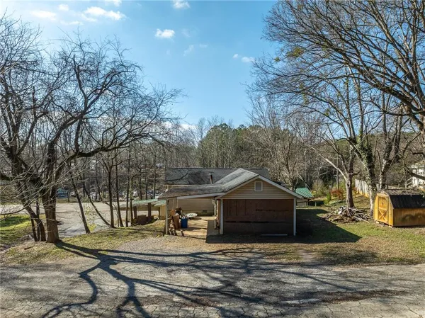 a view of a house with a yard and large tree