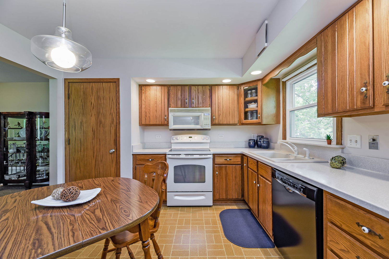 N150 County Farm Road Winfield, IL 60190 - Photo 7 of 22 a kitchen with stainless steel appliances granite countertop a sink dishwasher a stove a refrigerator with a dining table and chairs with wooden floor