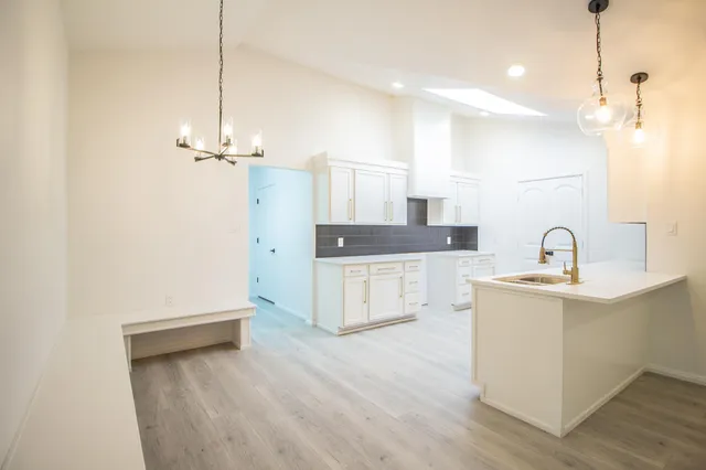 a large white kitchen with a sink a stove and refrigerator