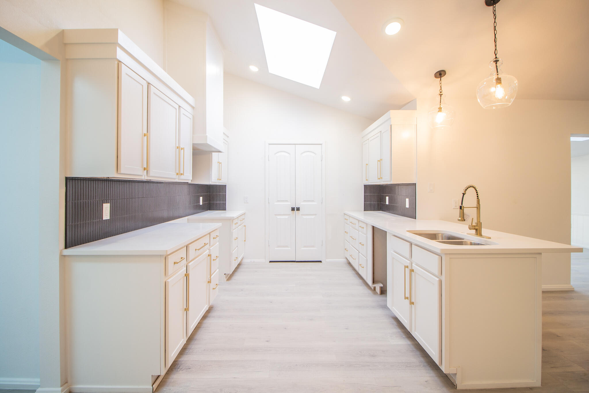 3602 63rd Drive Lubbock, TX 79413 - Photo 13 of 33 a large white kitchen with kitchen island a sink a stove and a refrigerator