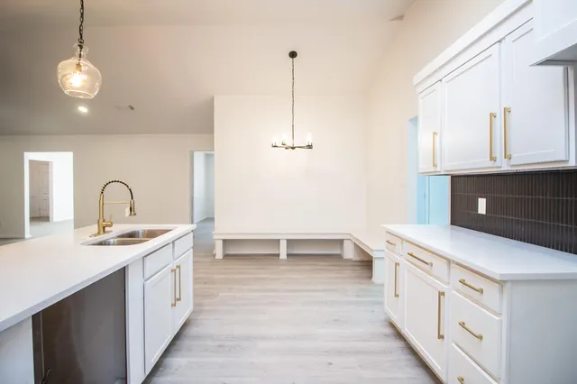 a kitchen that has a lot of cabinets in it and wooden floor