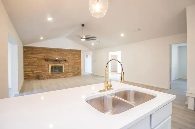 a kitchen with kitchen island a sink stainless steel appliances and a counter top space