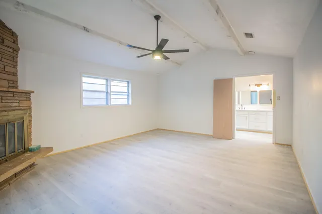 an empty room with fan and windows