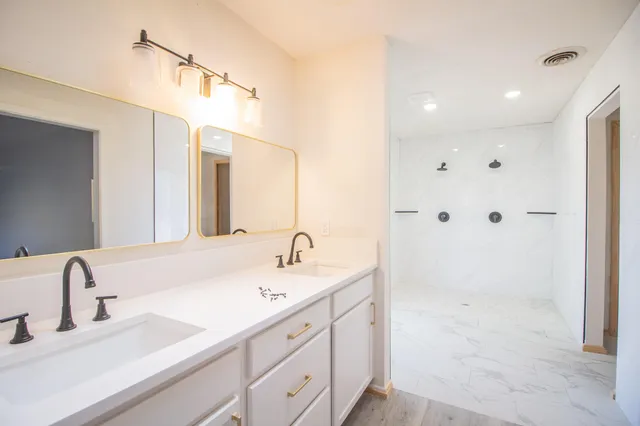 a bathroom with a double vanity sink mirror and double