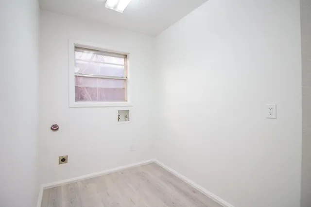 a view of a small space with wooden floor and a window