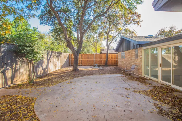 a backyard of a house with a large tree