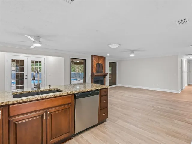 a open kitchen with granite countertop a sink and dishwasher with wooden floor