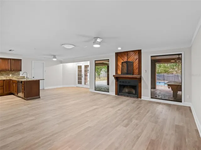 a view of an empty room with a window and fireplace