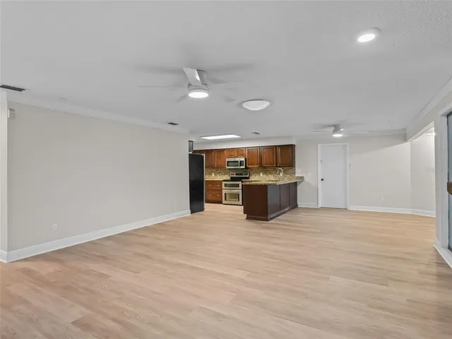 a view of an empty room with a kitchen