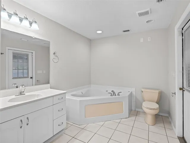 a spacious bathroom with a toilet sink and mirror