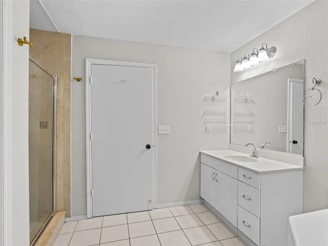 a spacious bathroom with a double vanity sink a mirror and a shower