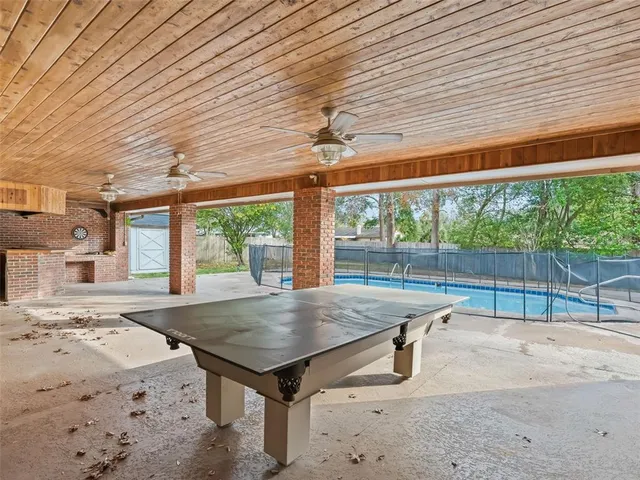 a room with pool table and windows