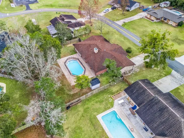 an aerial view of a house with a yard and large trees