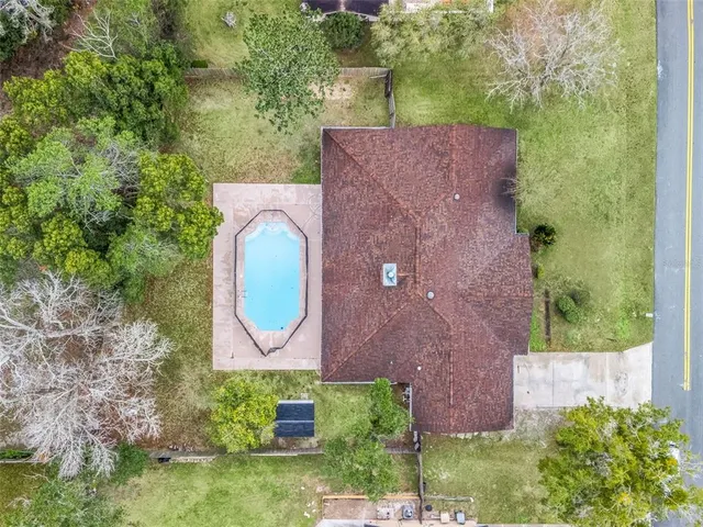 an aerial view of residential houses with outdoor space and trees