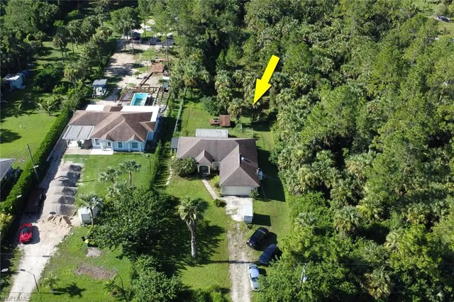 an aerial view of residential house with swimming pool and green space