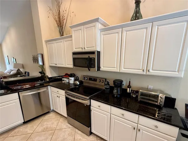 a kitchen with white cabinets a sink and appliances