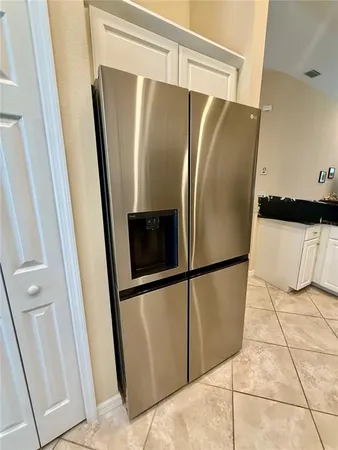 a metallic refrigerator freezer sitting in a kitchen