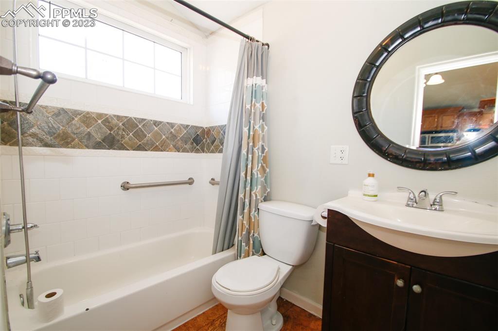 915 Alexander Road Colorado Springs, CO 80909 - Photo 14 of 24 a bathroom with a sink a toilet and a mirror