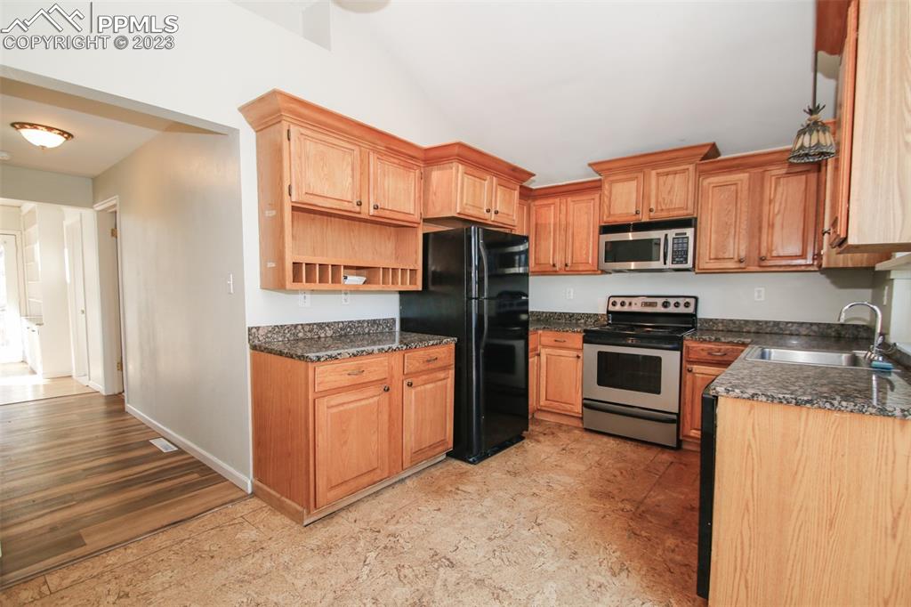 915 Alexander Road Colorado Springs, CO 80909 - Photo 17 of 24 a kitchen with stainless steel appliances granite countertop a refrigerator stove and oven