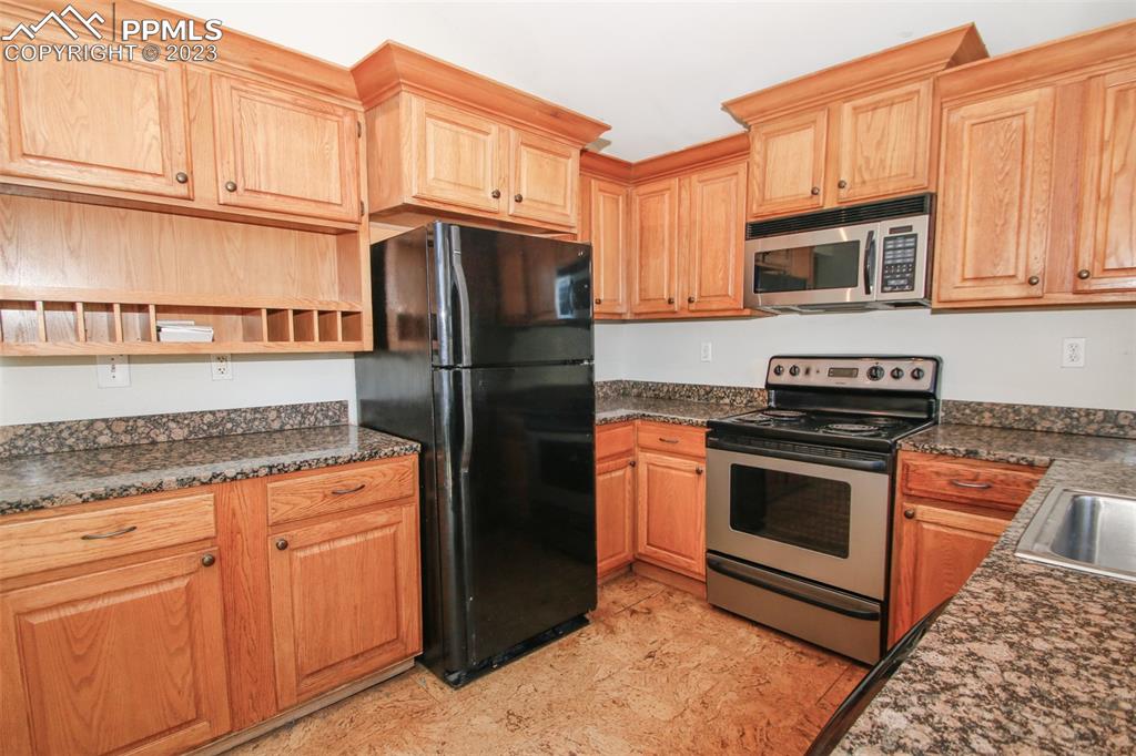 915 Alexander Road Colorado Springs, CO 80909 - Photo 19 of 24 a kitchen with stainless steel appliances granite countertop a refrigerator stove and sink