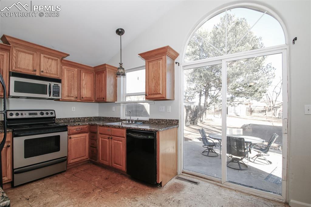 915 Alexander Road Colorado Springs, CO 80909 - Photo 20 of 24 a kitchen with stainless steel appliances granite countertop a stove sink and microwave